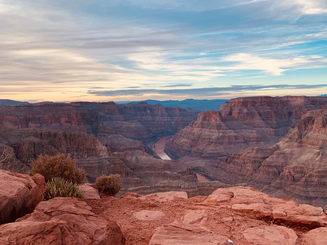 The South Rim of the Grand Canyon at sunrise with visitors on the viewing platform