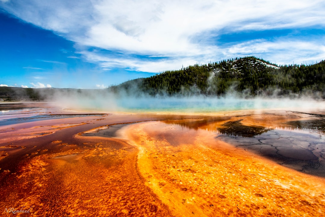 Yellowstone's Grand Prismatic Spring with its vivid orange and blue waters surrounded by steam