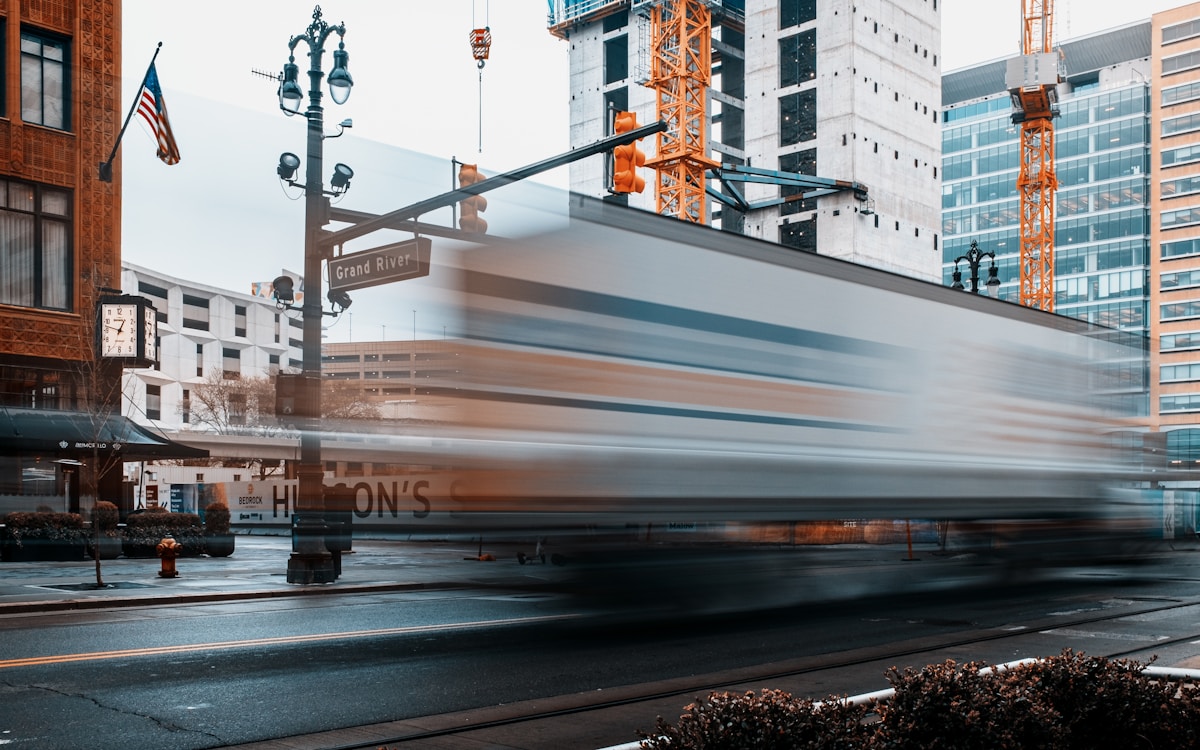 Train traveling down a city street next to tall buildings, Detroit, Michigan