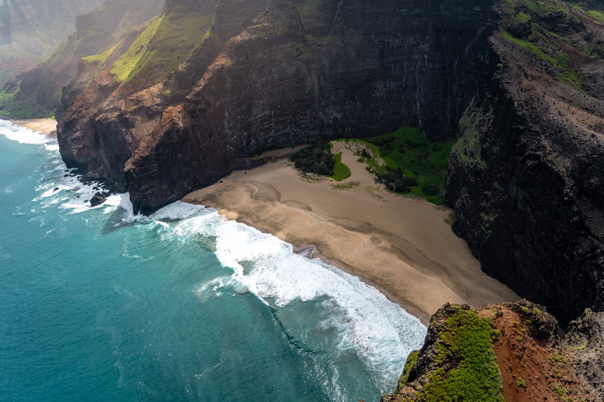 Tropical beach at sunset with palm trees and volcanic rocks in Maui, Hawaii