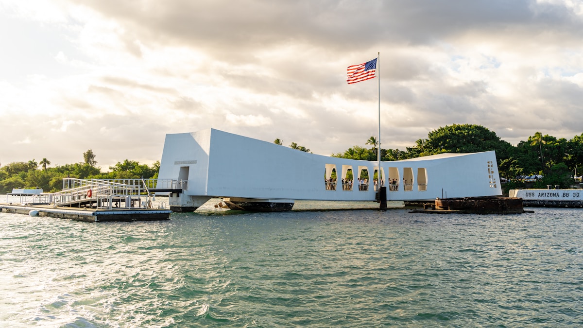 USS Arizona Memorial white structure with American flag over Pearl Harbor, Honolulu, Hawaii