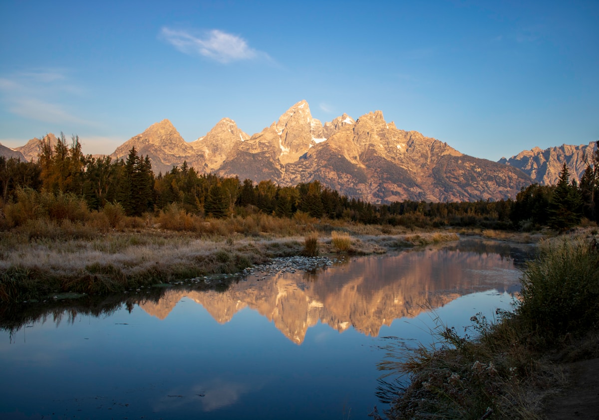Snow-capped mountains reflected in the still water of the Snake River, Jackson, Wyoming