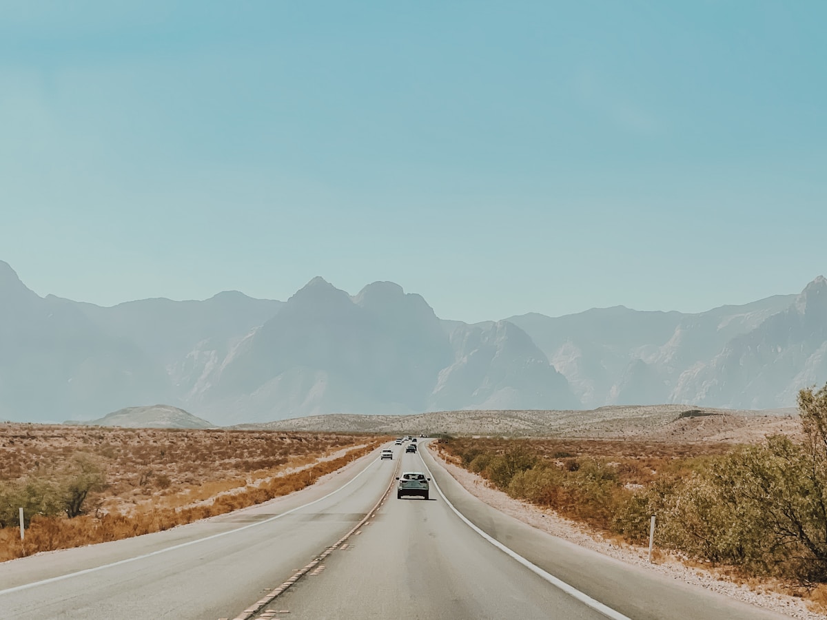 Car driving down a desert road with mountains near Las Vegas, Nevada