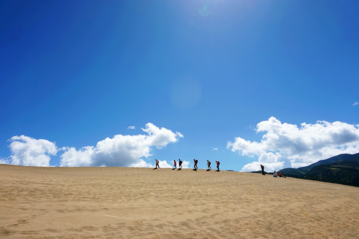 Hikers silhouetted on the crest of the vast sand dunes at Great Sand Dunes National Park, Colorado