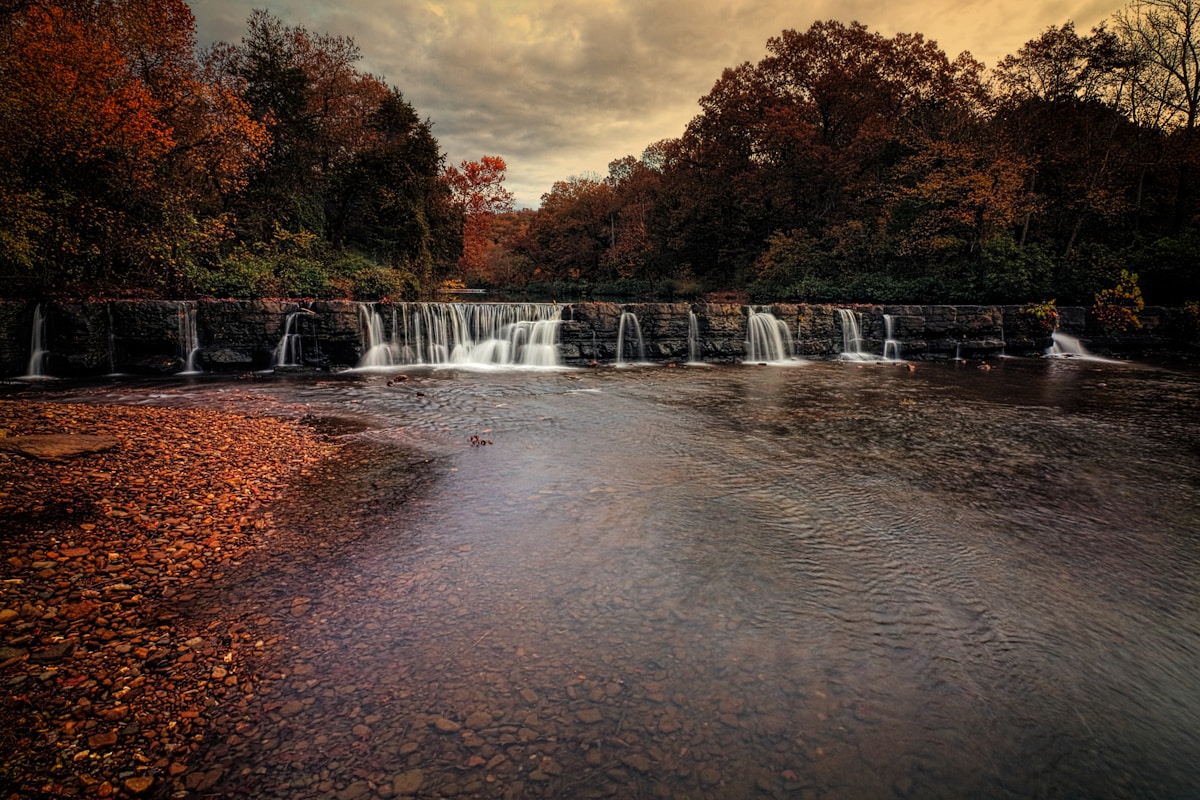 Autumn forest creek flowing over a natural stone dam in the Ouachita Mountains near Hot Springs, Arkansas
