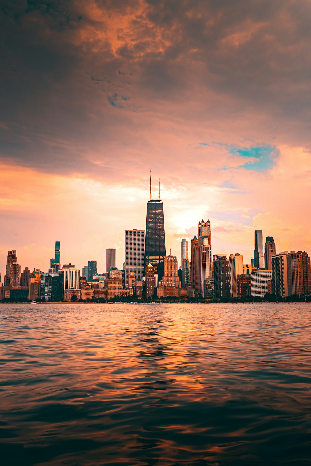 Chicago skyline with the John Hancock Center reflected across Lake Michigan at sunset