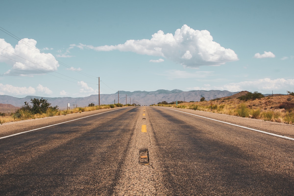Open two-lane road stretching to the horizon in the Arizona desert
