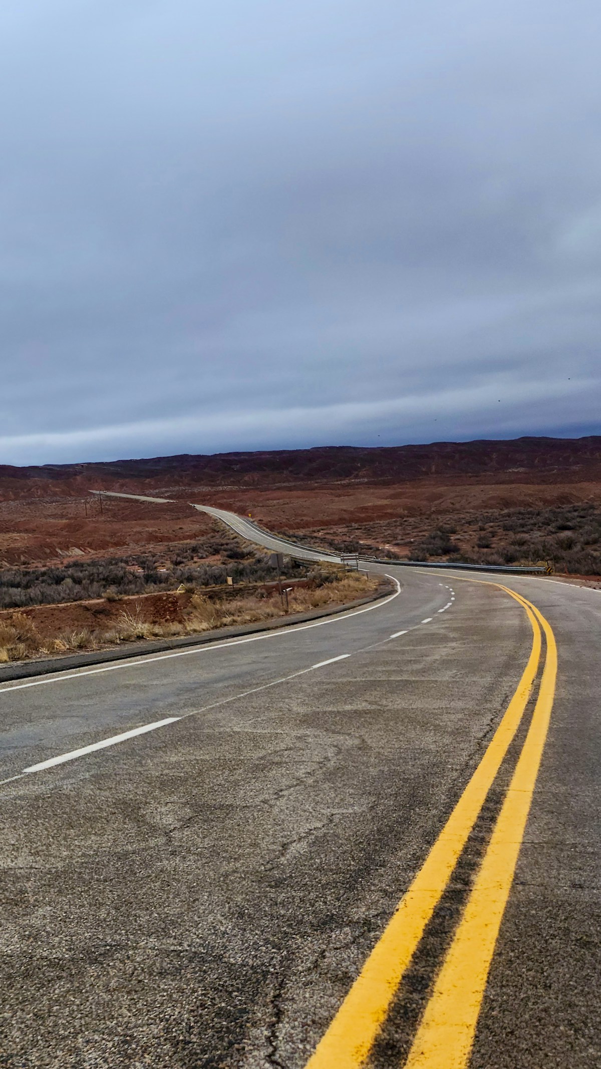 Empty desert highway stretching through red rock canyon country in Utah, USA