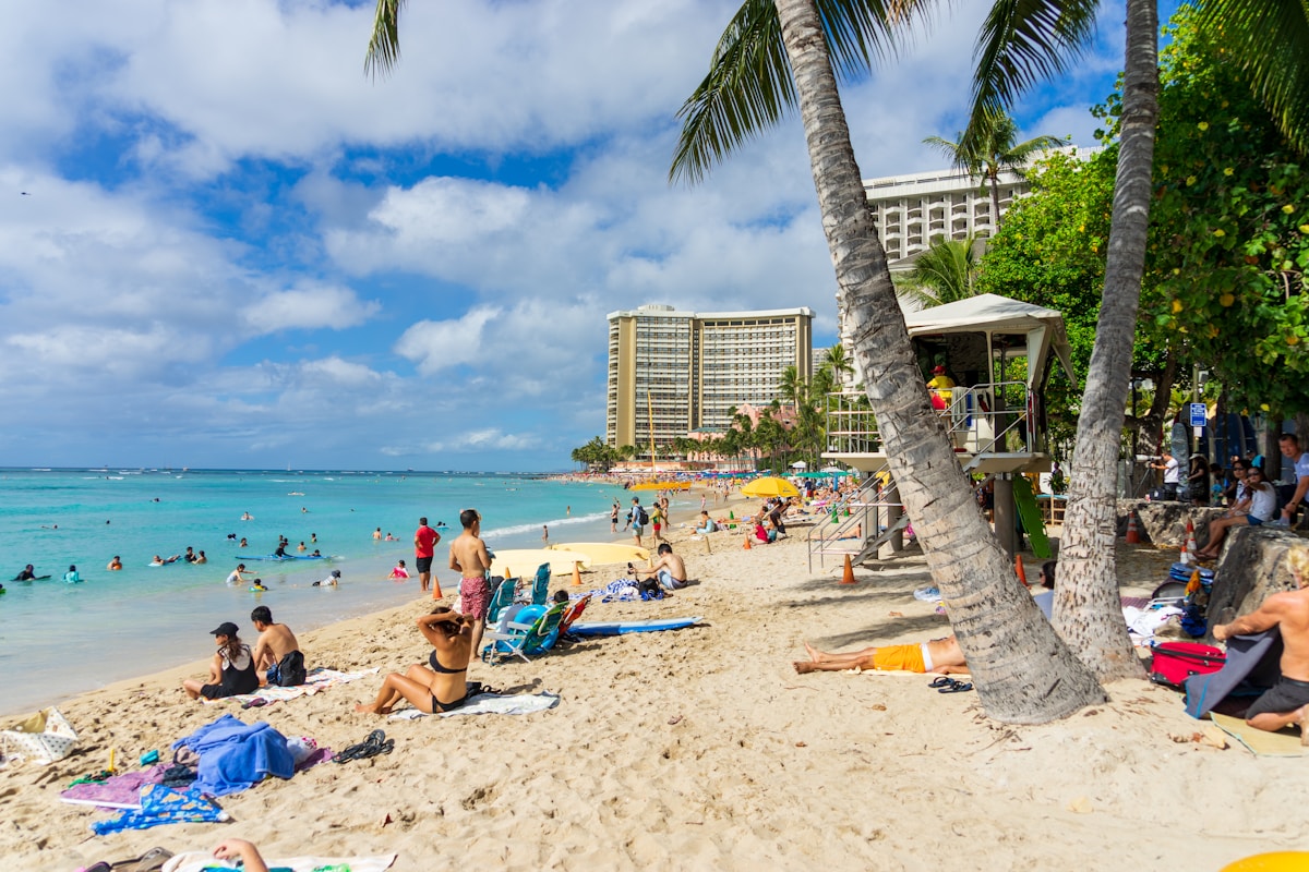 Waikiki Beach crowded with swimmers in clear turquoise water, Honolulu, Hawaii