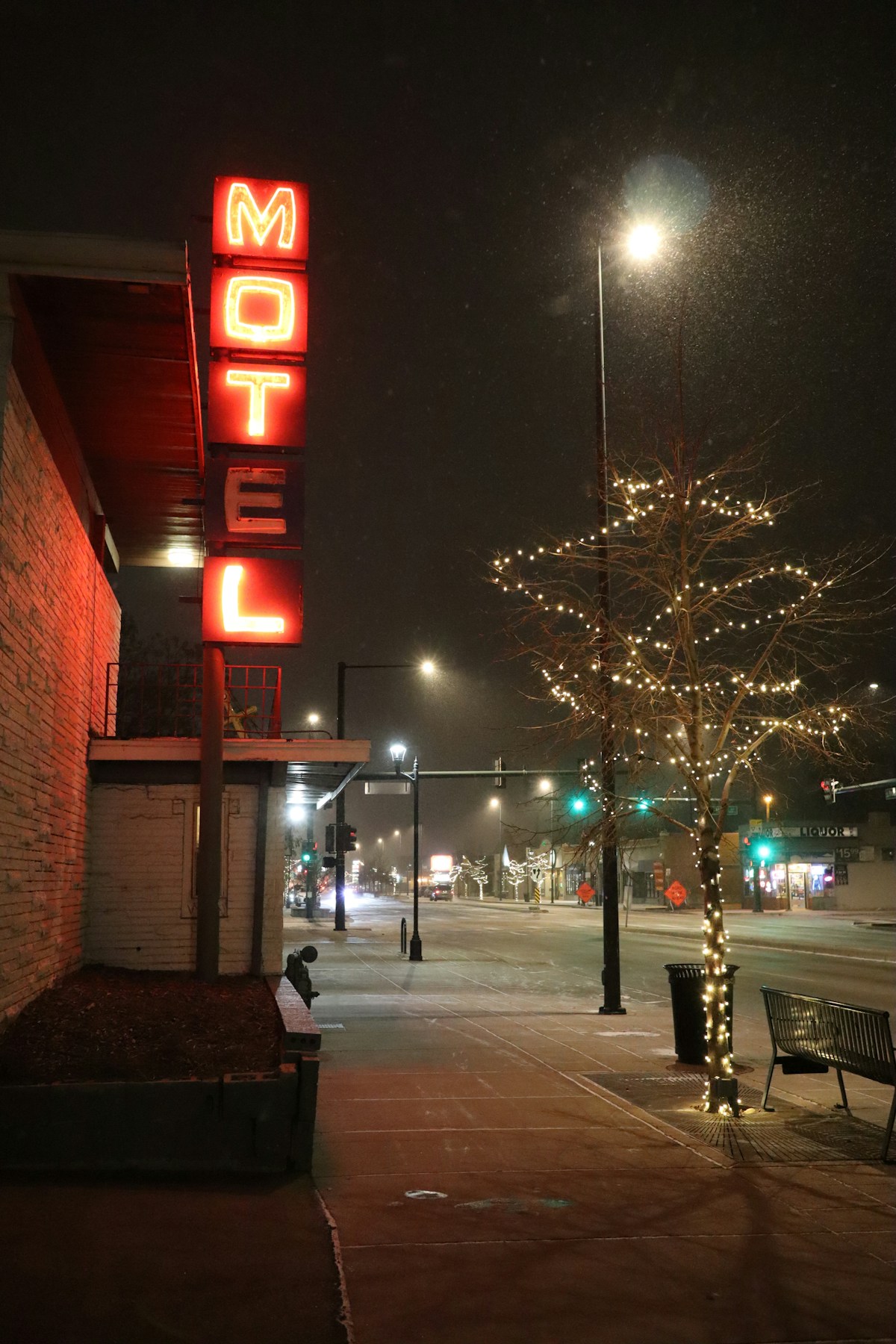 Red neon motel sign glowing over a night-time street