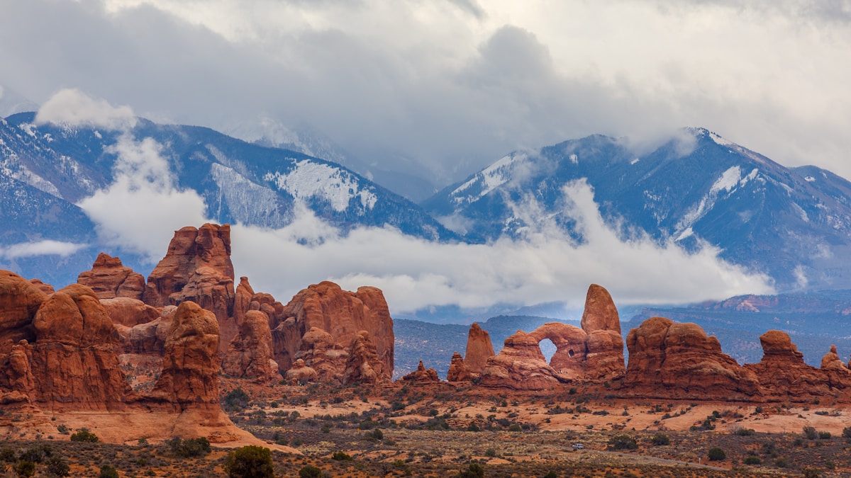 Sandstone arch formation under white clouds and blue sky, Arches National Park, Utah