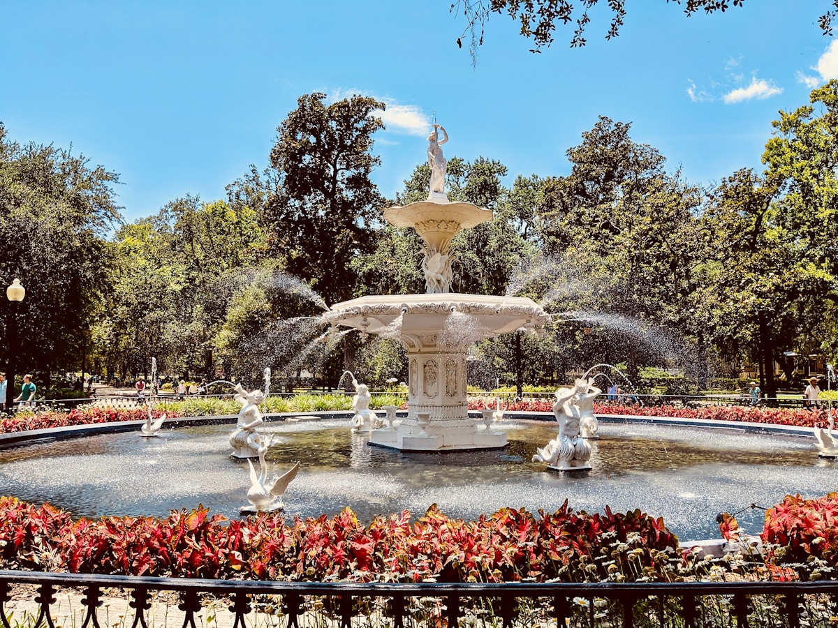 Red flowers blooming around the white Forsyth Park fountain in Savannah, Georgia