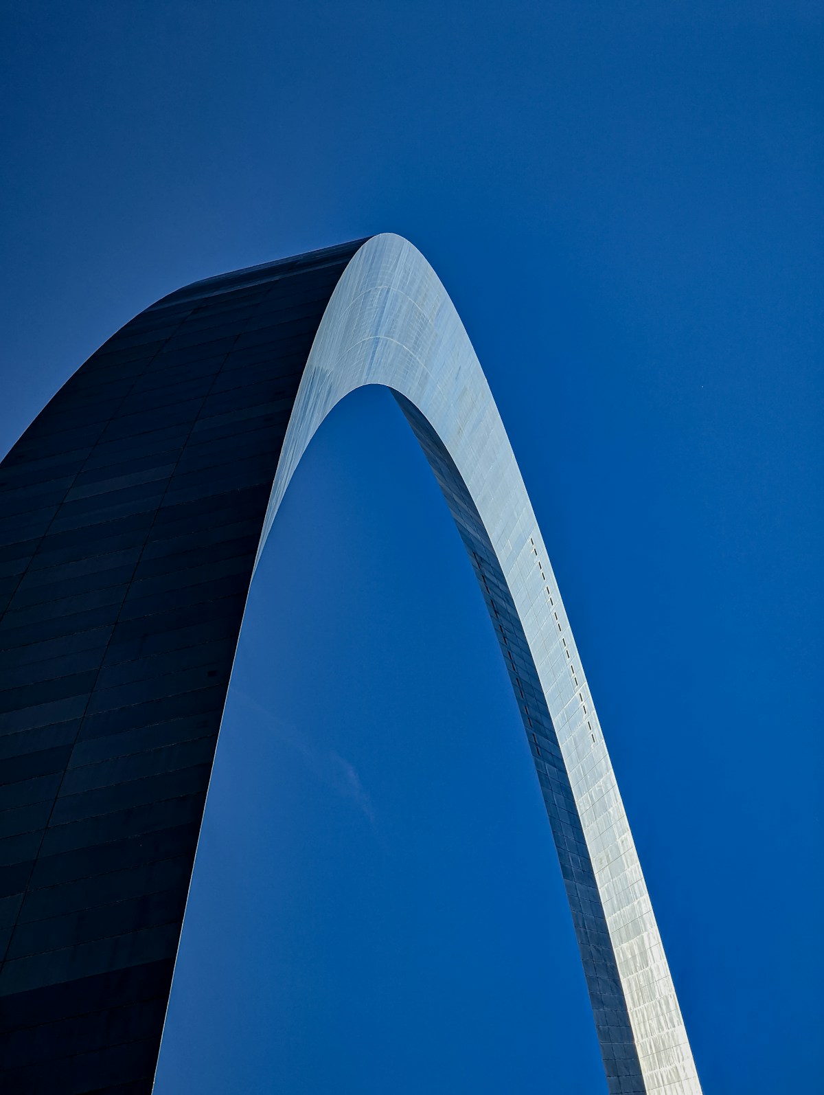 The Gateway Arch framed against a blue sky beside the Mississippi River, St. Louis