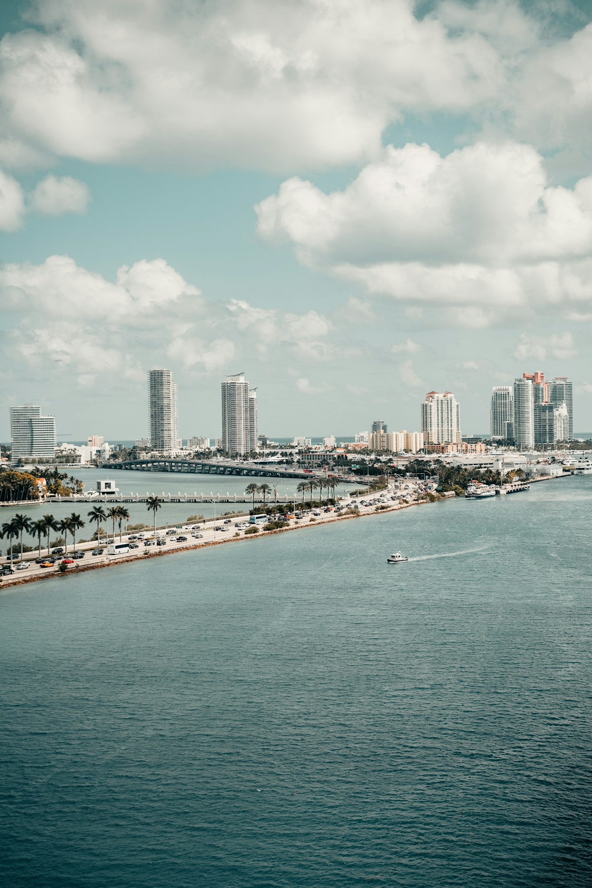 Miami Beach skyline across Biscayne Bay with palm trees and clear blue sky, Florida