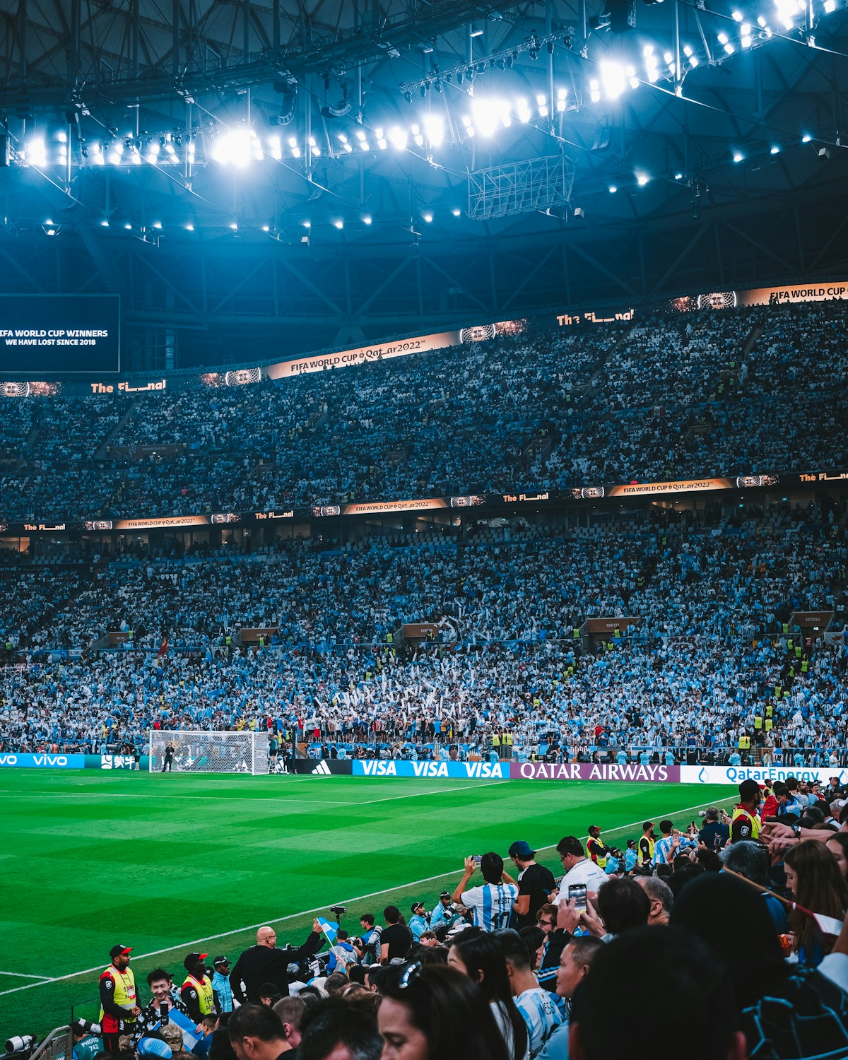 Packed soccer stadium under floodlights during an evening match